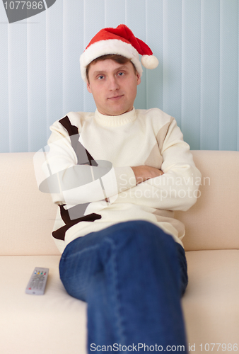 Image of People in a Christmas hat sits on a sofa