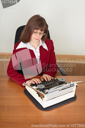 Image of Woman prints on an ancient typewriter