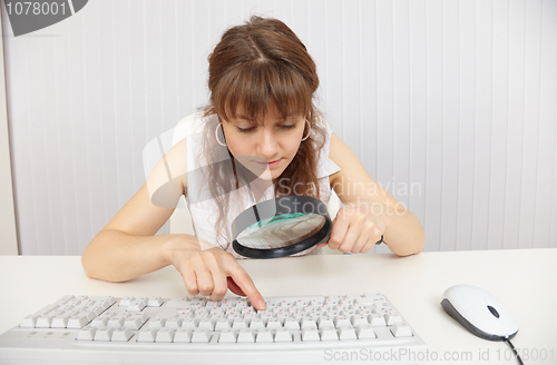 Image of Young blind woman works with keyboard by means of magnifier