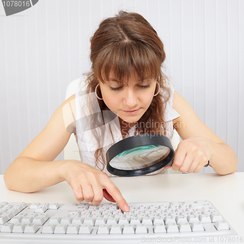 Image of Girl with poor eyesight works with computer keyboard