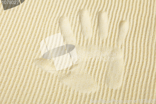 Image of Trace from palm on surface of yellow sand