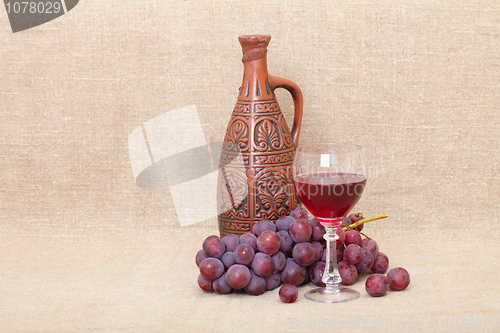 Image of Art composition from clay bottle, grapes and glass
