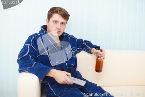 Image of Person has a rest in a dressing gown on sofa