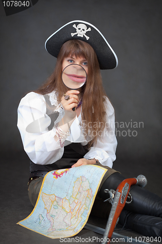 Image of Woman - captain of sea pirates with map and magnifier in hands