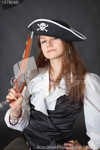 Image of Portrait of beautiful girl in pirate hat with pistol in hand