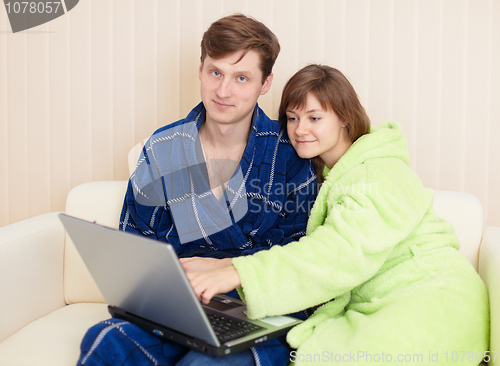 Image of Young pair on sofa with laptop