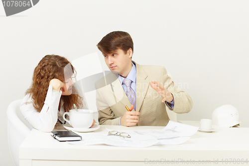 Image of Businessman explains to missing tired girl drinking coffee