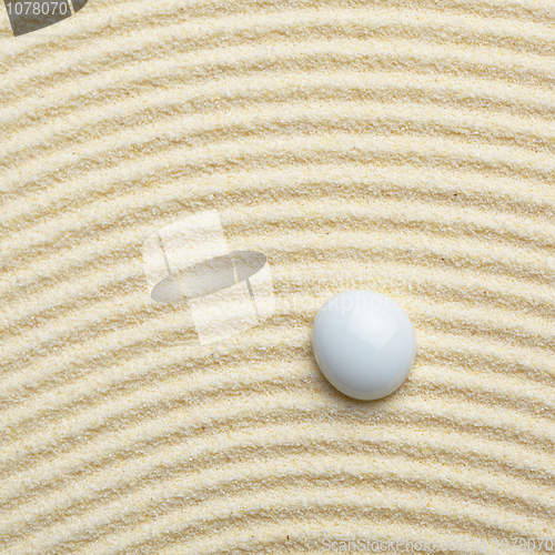 Image of Stone on surface of yellow sand - square composition