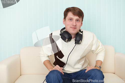 Image of Man with head-phones on sofa