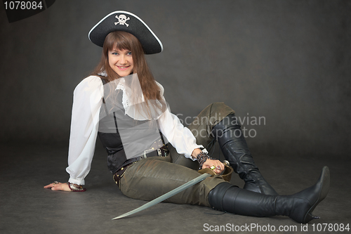 Image of Sexy woman - pirate sits on black background