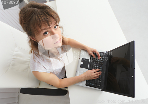 Image of Woman working with laptop looks at us