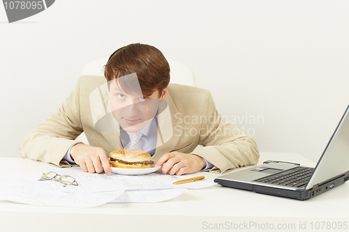 Image of Young businessman is going to have dinner hamburger at office