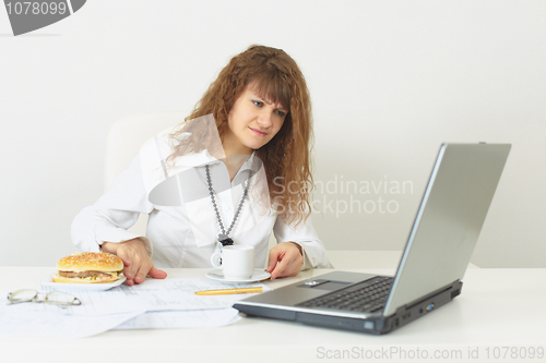 Image of Young beautiful girl refuses meal on workplace