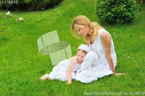 Image of Young mother and daughter resting in meadow