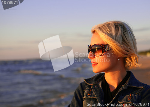 Image of young blond woman looking at sunset