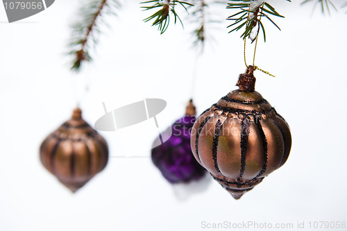 Image of Christmas baubles on a snowy pine