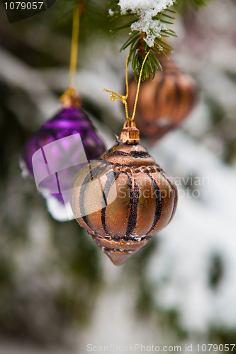 Image of Christmas baubles on a snowy pine