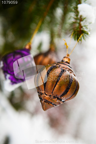 Image of Christmas baubles on a snowy pine