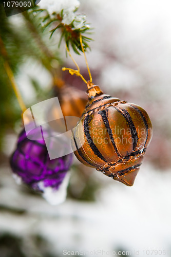 Image of Christmas baubles on a snowy pine
