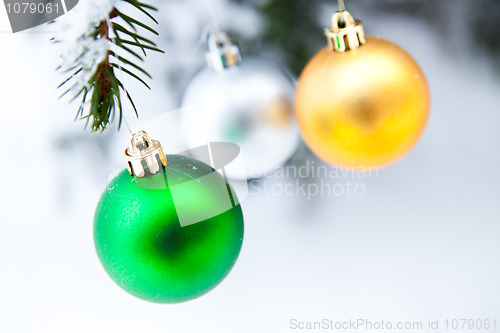 Image of Christmas baubles on a snowy pine