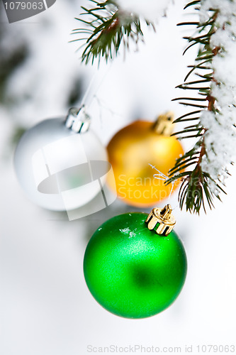 Image of Christmas baubles on a snowy pine