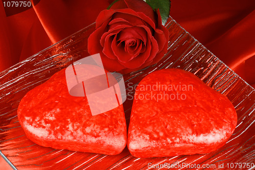Image of Two red heart shaped cakes and a rose