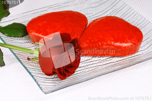 Image of Two red heart shaped cakes and a rose