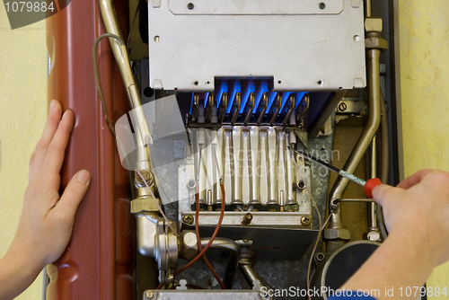 Image of hands of a plumber repairing a gas heating 