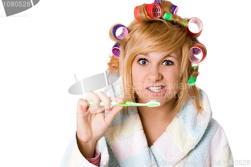 Image of funny housewife with curlers and toothbrush 