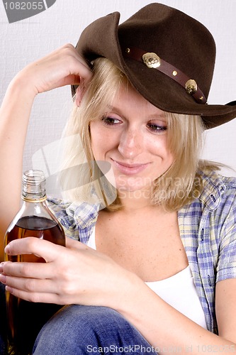 Image of  woman cowboy with bottle of whiskey