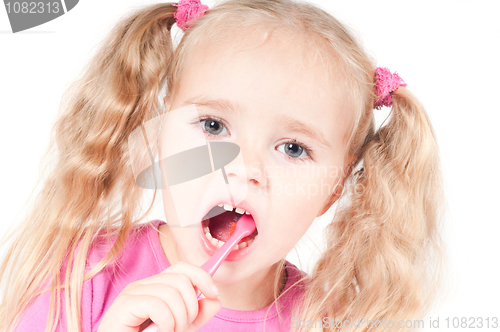 Image of Little cute girl in studio brushing teeth