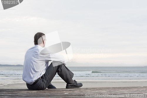 Image of Pensive businessman sitting at the sea