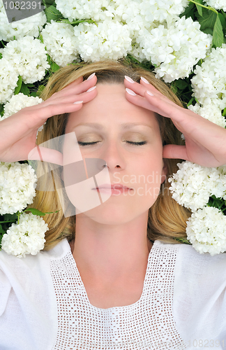 Image of Young woman laying in flowers - snowballs