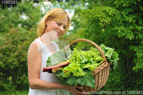 Image of Young woman holding basket with vegetable