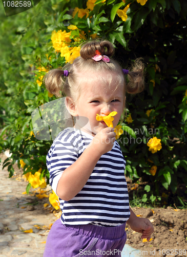 Image of little girl smelling flower