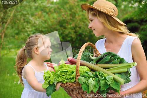 Image of Young woman and daughter with fresh vegetable