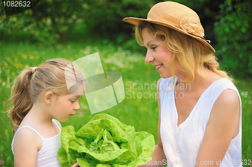 Image of Young mother and daughter with lettuce