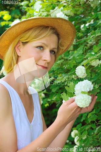 Image of Young woman gardening - taking care of snowball