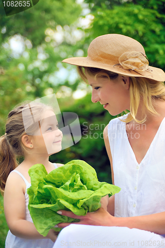 Image of Young mother and daughter with lettuce