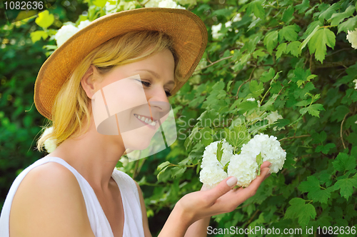 Image of Young woman gardening - taking care of snowball