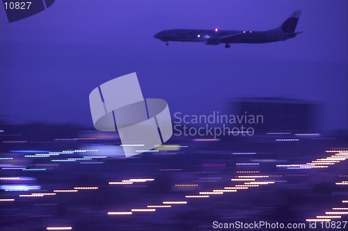 Image of A jet approaches the runway at night for landing at the Los Angeles International Airport, USA.Panned shot.