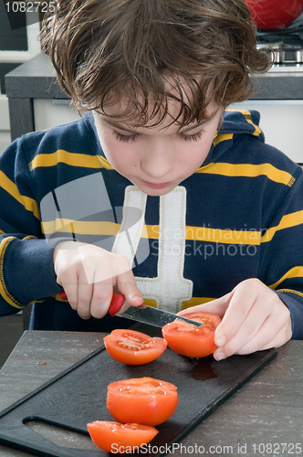 Image of Boy cutting tomato