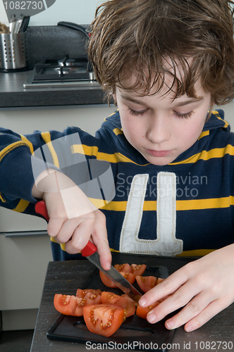 Image of Boy cutting tomato