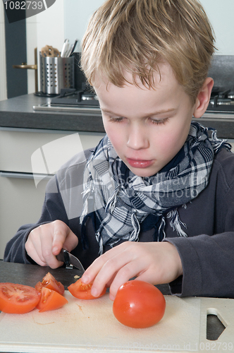 Image of Boy cutting tomato