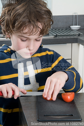 Image of Boy cutting tomato