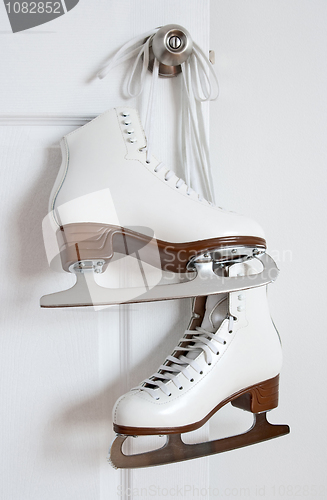 Image of Figure skates hanging on a door knob