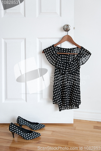 Image of Polka dot shoes and stylish blouse on a hanger