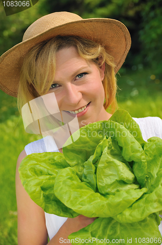 Image of Young woman holding fresh lettuce