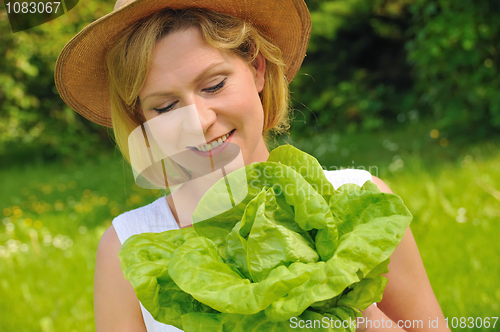 Image of Young woman holding fresh lettuce