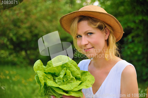 Image of Young woman holding fresh lettuce